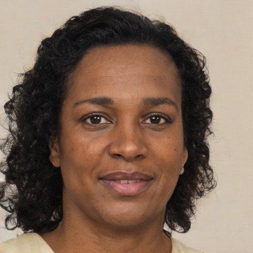 Joyful black adult female with long  brown hair and brown eyes