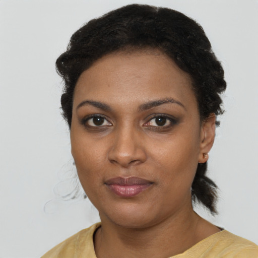 Joyful black young-adult female with short  brown hair and brown eyes