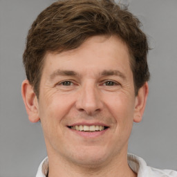 Joyful white adult male with short  brown hair and brown eyes