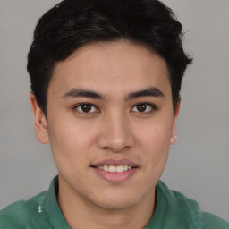 Joyful latino young-adult male with short  brown hair and brown eyes