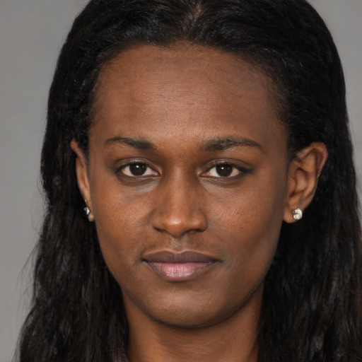 Joyful black young-adult female with long  brown hair and brown eyes