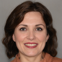 Joyful white adult female with medium  brown hair and brown eyes