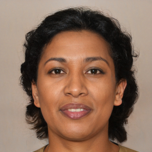 Joyful black adult female with medium  brown hair and brown eyes