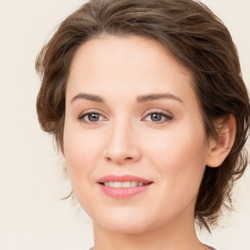 Joyful white young-adult female with medium  brown hair and green eyes