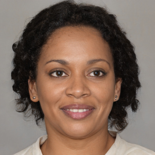 Joyful black adult female with medium  brown hair and brown eyes