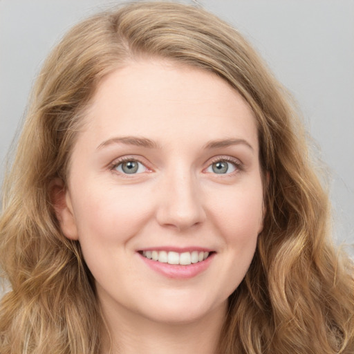 Joyful white young-adult female with long  brown hair and blue eyes