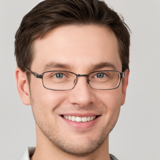 Joyful white young-adult male with short  brown hair and grey eyes