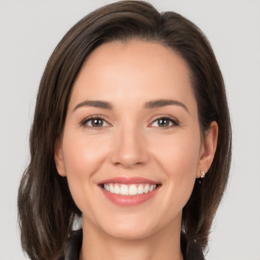 Joyful white young-adult female with long  brown hair and brown eyes