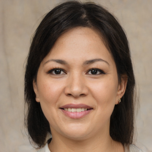 Joyful asian adult female with medium  brown hair and brown eyes
