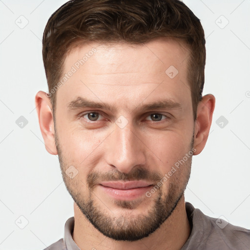 Joyful white young-adult male with short  brown hair and grey eyes