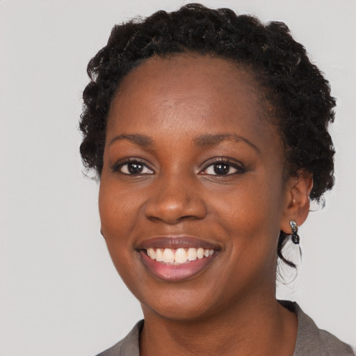Joyful black young-adult female with short  brown hair and brown eyes