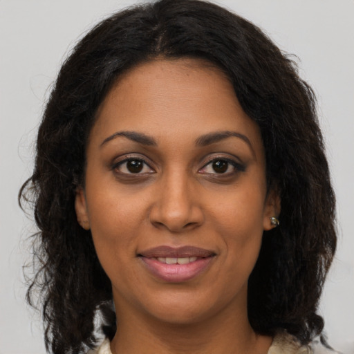 Joyful black young-adult female with medium  brown hair and brown eyes