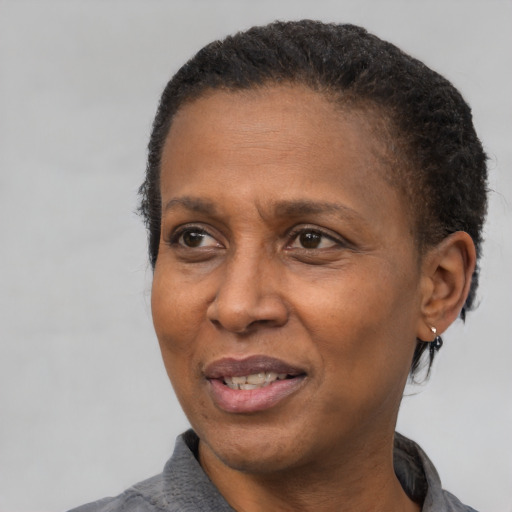 Joyful black adult female with short  black hair and brown eyes