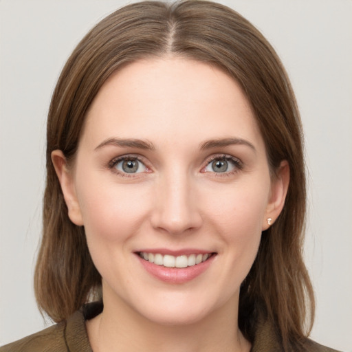 Joyful white young-adult female with medium  brown hair and grey eyes