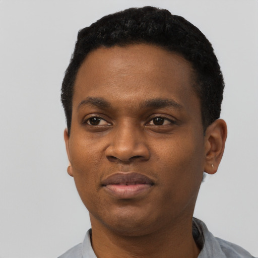 Joyful black young-adult male with short  black hair and brown eyes