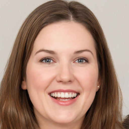 Joyful white young-adult female with long  brown hair and grey eyes