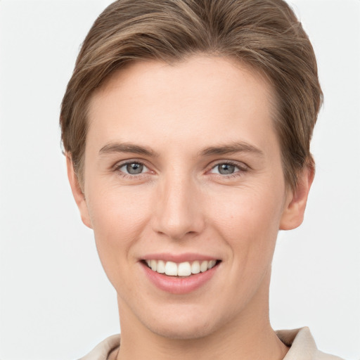 Joyful white young-adult female with short  brown hair and grey eyes