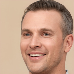 Joyful white adult male with short  brown hair and brown eyes