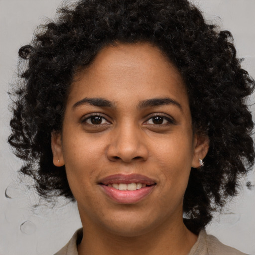 Joyful black young-adult female with medium  brown hair and brown eyes