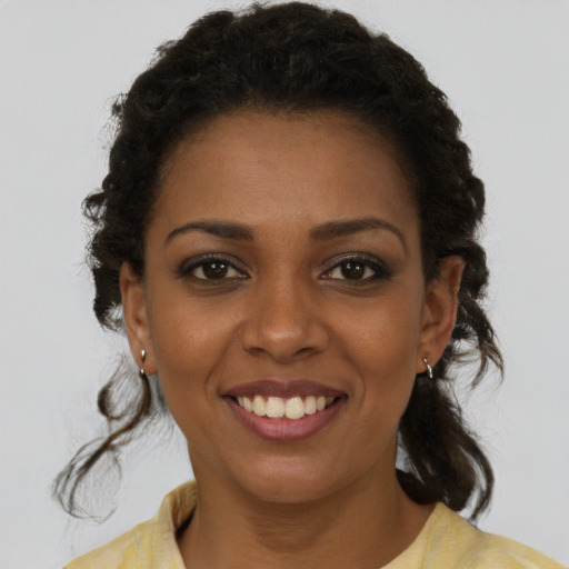 Joyful black young-adult female with medium  brown hair and brown eyes
