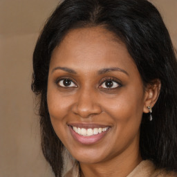 Joyful black adult female with long  brown hair and brown eyes