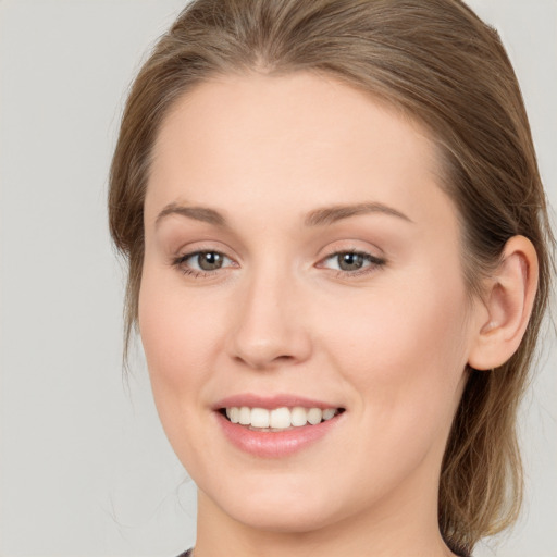 Joyful white young-adult female with long  brown hair and grey eyes