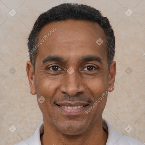 Joyful black adult male with short  black hair and brown eyes