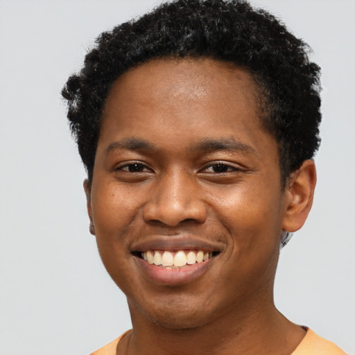Joyful black young-adult male with short  brown hair and brown eyes