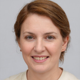 Joyful white adult female with medium  brown hair and grey eyes