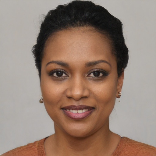 Joyful black young-adult female with short  black hair and brown eyes