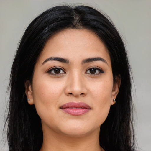Joyful latino young-adult female with long  brown hair and brown eyes