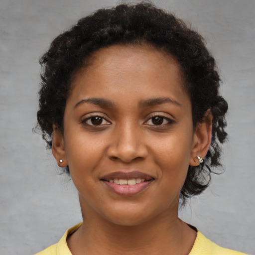 Joyful black young-adult female with short  brown hair and brown eyes