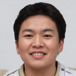 Joyful asian young-adult male with short  brown hair and brown eyes