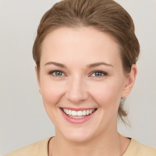 Joyful white young-adult female with short  brown hair and grey eyes