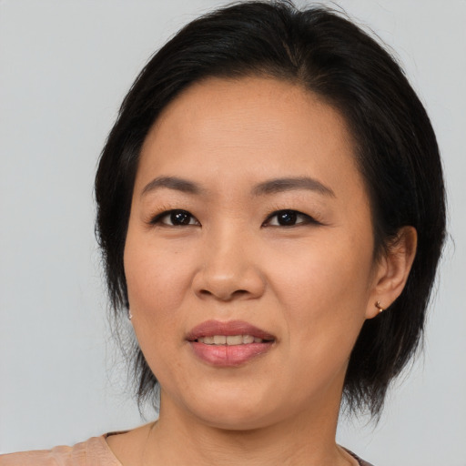 Joyful asian adult female with medium  black hair and brown eyes