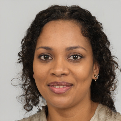 Joyful black young-adult female with long  brown hair and brown eyes