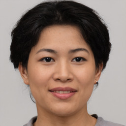 Joyful asian young-adult female with short  brown hair and brown eyes