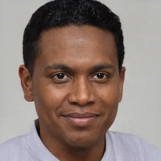 Joyful black young-adult male with short  brown hair and brown eyes