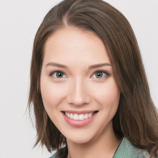 Joyful white young-adult female with medium  brown hair and green eyes