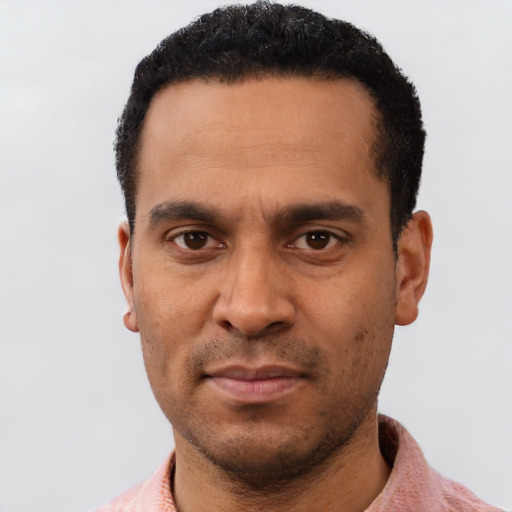 Joyful latino adult male with short  black hair and brown eyes