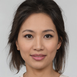 Joyful asian young-adult female with medium  brown hair and brown eyes