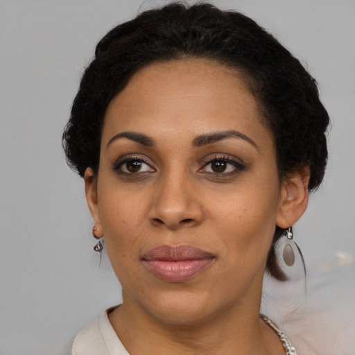 Joyful black young-adult female with short  brown hair and brown eyes