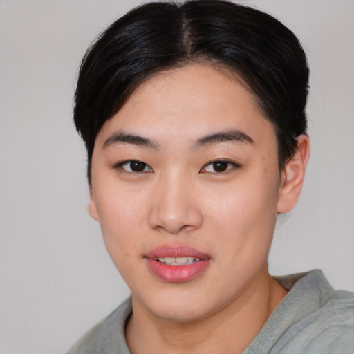 Joyful asian young-adult female with short  brown hair and brown eyes