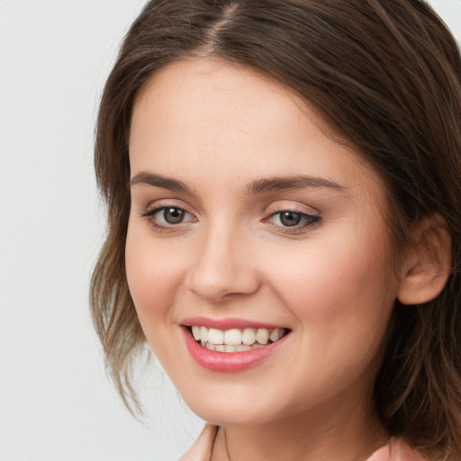 Joyful white young-adult female with long  brown hair and green eyes