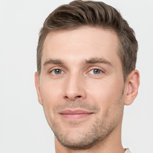 Joyful white young-adult male with short  brown hair and grey eyes