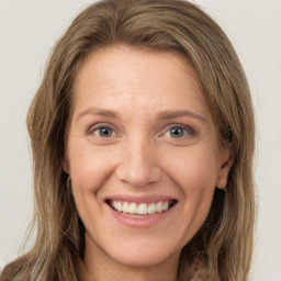 Joyful white young-adult female with long  brown hair and green eyes