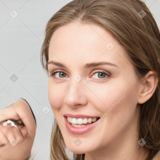 Joyful white young-adult female with long  brown hair and grey eyes