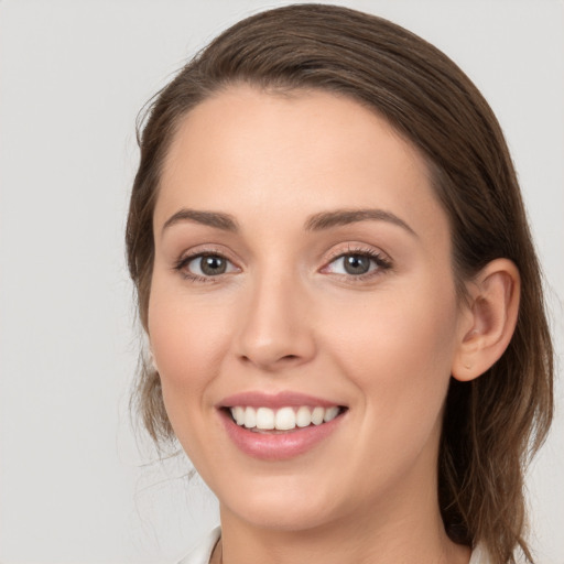 Joyful white young-adult female with medium  brown hair and grey eyes