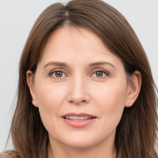 Joyful white adult female with long  brown hair and grey eyes