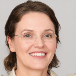 Joyful white adult female with medium  brown hair and blue eyes